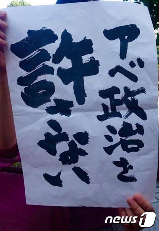 일본 시인 가네코 도타가 만든 '아베 정치를 용서할 수 없다'는 문구.(출처=사와치 히사에 트위터)© 뉴스1