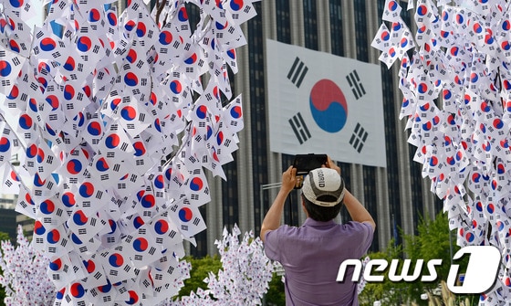 광복70주년을 이틀 앞둔 13일 오후 서울 광화문광장을 찾은 한 시민이 광장에 조성된 태극기 나무를 휴대폰으로 사진을 찍고 있다.  © News1 박세연 기자