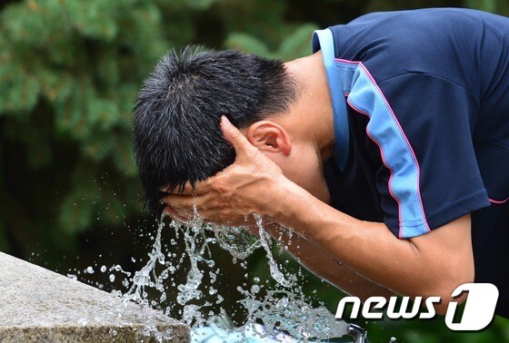 폭염이 시작되면서 서울 효창공원 수돗가에서 한 시민이 땀을 씻어 내고 있다./뉴스1 © News1 손형주 기자