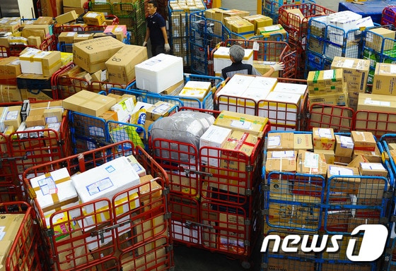 14일 저녁 부산 강서구 대저동 우편집중국에서 직원들이 물량이 늘어난 소포와 택배를 분류작업에 힘 쓰고 있다.2015.9.15/뉴스1 © News1 이승배 기자
