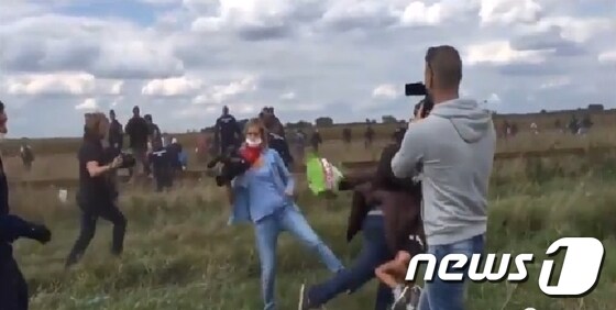 헝가리와 세르비아 국경에서 경찰 저지선을 뚫고 난민 캠프를 떠나던 장면을 촬영하던 헝가리 극우 성향의 N1TV의 카메라기자가 아이를 안고 달리던 남성에게 발을 거는 장면 (출처: Facebookable 유튜브) © 뉴스1
