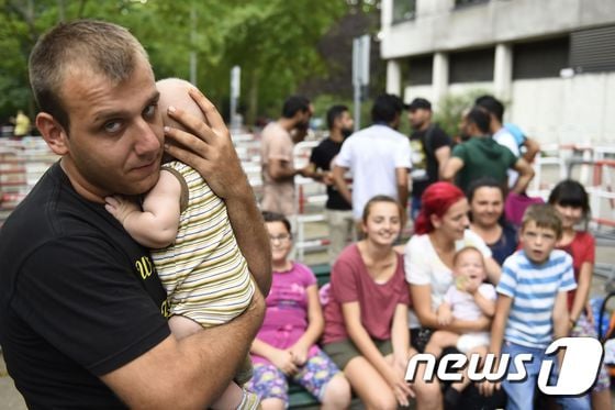독일 난민들이 지난해 8월 주 정부 청사 앞에 앉아 있다. © AFP=뉴스1