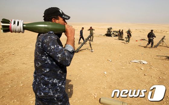 이라크 정부군이 23일(현지시간) 모술 남쪽 마을인 알쿠와인에서 박격포탄을 들고 이동하고 있다. © AFP=뉴스1