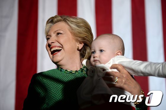 힐러리 클린턴 미국 민주당 대선 후보가 23일 (현지시간) 노스캐롤라이나 주 샬럿의 선거유세에서 아이를 안고 있다. © AFP=뉴스1