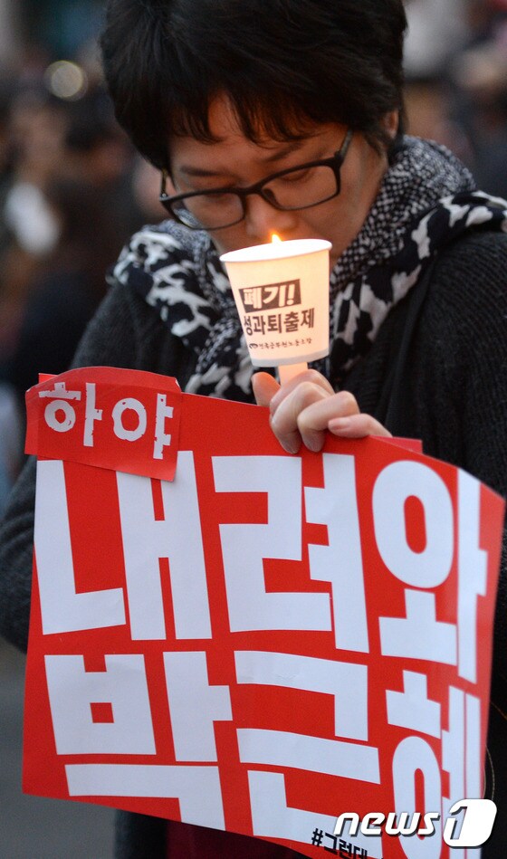 '2016 민중총궐기 대회'인 12일 서울 시청역 앞에서 시민이 촛불을 들고 '대통령 하야'를 촉구 하고 있다. 2016.11.12/뉴스1 © News1 황기선 기자