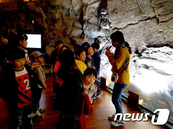암각화박물관의 반구대암각화 실물모형 앞에서 문화관광헤설사의 설명을 듣고 있다. © News1 이상문 기자