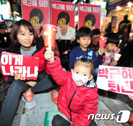 19일 대구 중구 중앙로에서 열린 '3차 시국대회'에 참가한 시민들이 '박근혜 대통령 퇴진'를 촉구하는 피킷과 촛불을 들고 있다.2016.11.19/뉴스1 © News1 정지훈 기자