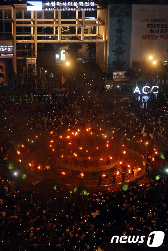 19일 오후 광주 동구 5·18민주광장에서 '박근혜 대통령 퇴진 촛불집회'가 열린 가운데 시민들이 분수대를 둘러싸고 횃불을 들고 있다. 2016.11.19/뉴스1 © News1 윤용민 기자