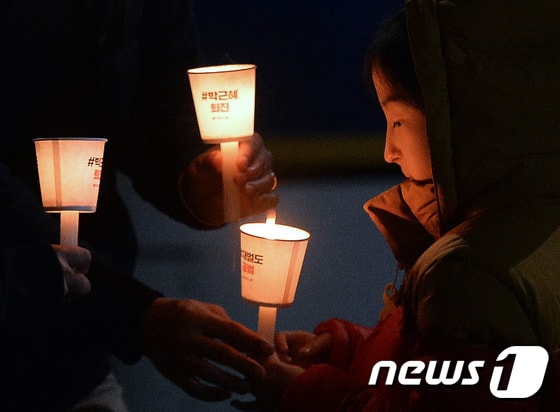 '박근혜 대통령 퇴진을 요구하는 4차 촛불집회'가 열린 19일 저녁 서울 종로구 내자동 로터리에서 참가자들이 촛불을 전하고 있다.2016.11.19/뉴스1 © News1 구윤성 기자