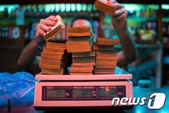 베네수엘라에서 한 상인이 지폐의 무게를 세고 있다. (트위터) © News1