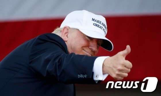 도널드 트럼프 미국 공화당 대통령 후보가 '미국을 다시 위대하게'라는 슬로건이 쓰인 야구모자를 쓰고 엄지손가락을 치켜올리고 있다. © AFP=뉴스1