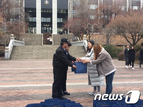21일 오후 숙명여대 학생들이 경비·청소노동자에게 선물을 전달하고 있다.(숙명여대 비대위 제공)© News1