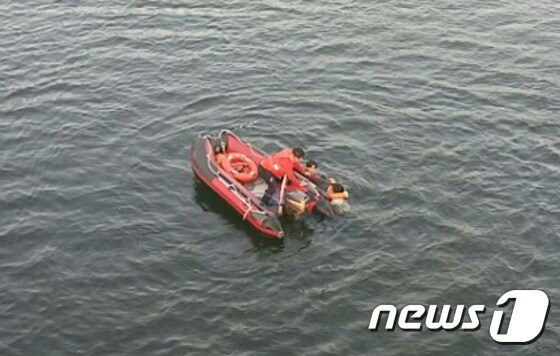 지난 27일 오후 4시10분쯤 경북 안동댐 영락교에서 투신한 40대 여성을 경찰이 물속에 뛰어들어 구조하고 있다./사진=독자제공 © News1