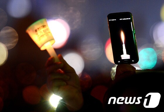 지난달 31일 오후 서울 광화문광장에서 열린 제10차 범국민행동에 참석한 시민들이 촛불을 들고 박근혜 대통령 조기 퇴진을 촉구하고 있다. 2016.12.31/뉴스1 © News1 박세연 기자