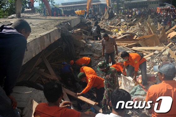 7일(현지시간) 인도네시아 서부를 강타한 규모 6.5의 강진으로 폐허가 된 아체주 피디에 자야에서 구조팀이 생존자 수색 및 시신 수습 작업을 벌이고 있다. © AFP=뉴스1