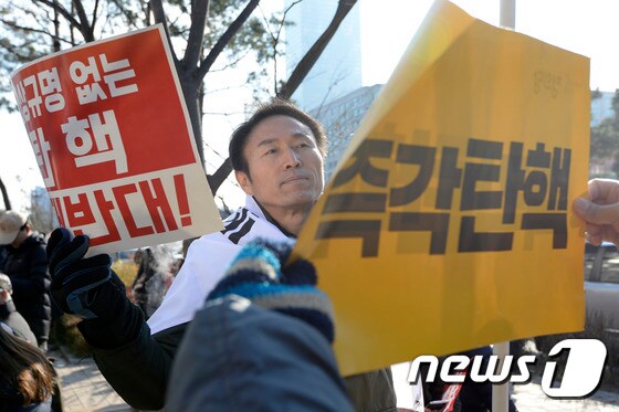 박근혜 대통령 탄핵 표결을 앞둔 9일 오후 서울 여의도 국민은행 앞에서 '진상규명 없는 탄핵 절대반대!'라는 피켓을 든 시민과 '즉각 탄핵'이라는 피켓을 든 시민이 서로 마주보고 있다. 2016.12.9/뉴스1 © News1 안은나 기자