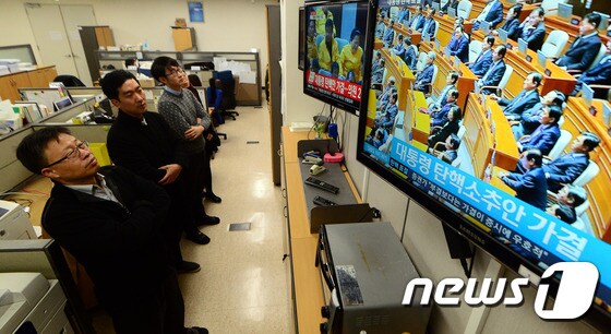 박근혜 대통령에 대한 탄핵소추안이 가결된 9일 정부세종청사 국무조정실·국무총리비서실에서 직원들이 국회 생방송을 지켜보고 있다. © News1 장수영 기자