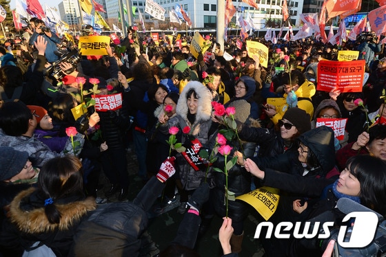 박근혜 대통령의 탄핵안이 가결된 9일 오후 서울 여의도 국회 앞에서 시민들이 장미꽃을 흔들며 기뻐하고 있다. 2016.12.9/뉴스1 © News1 최현규 기자