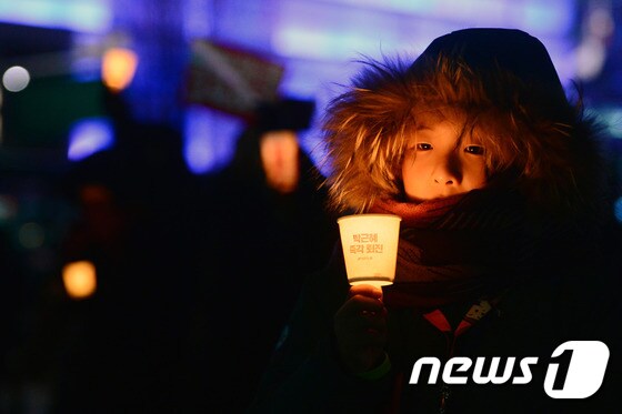 박근혜 대통령의 탄핵안이 가결된 9일 오후 서울 광화문광장에서 열린 '국민주권 문화제'에서 한 아이가 촛불을 들고 있다. 2016.12.9/뉴스1 © News1 최현규 기자
