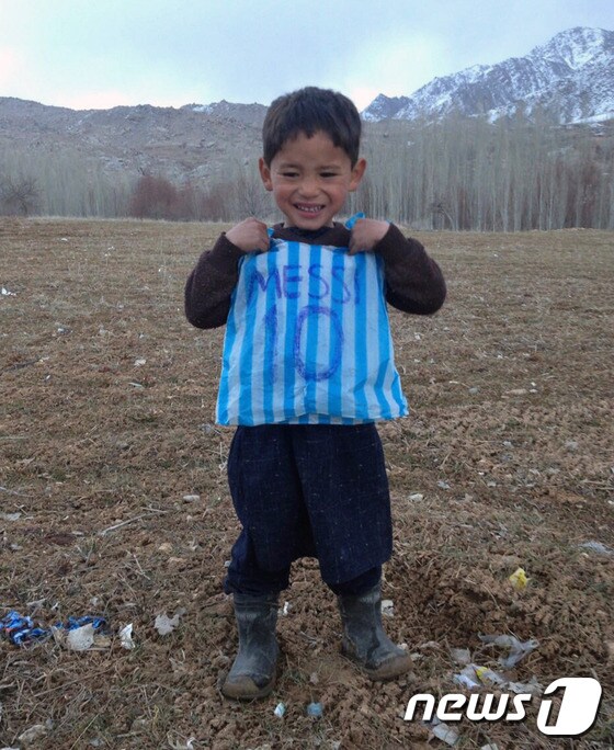 형이 만들어준 비닐 유니폼을 입고 환하게 웃고 있는 무르타자 아흐마디(5)©AFP=News1