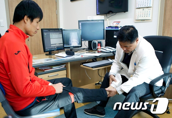 조선대병원 정형외과 이준영 교수(오른쪽)가 정조국 축구선수를 진료하고 있는 모습.(조선대병원 제공) 2016.2.2.© News1