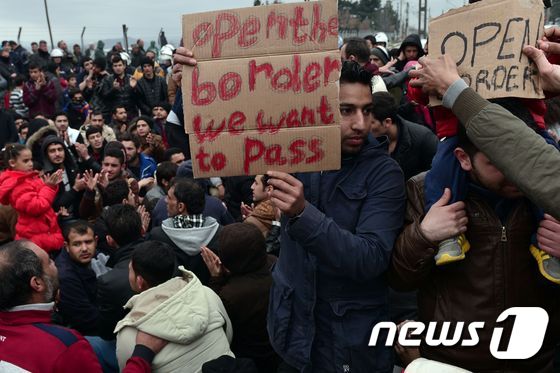 시리아, 이라크 난민들이 28일 (현지시간) 이도메니에서 그리스-마케도니아 국경의 개방을 요구하면서 시위를 하고 있다. 최근 발칸 4개국이 하루 입국자의 상한을 정하면서 5000명 이상의 난민들이 그리스에 발이 묶여 있다.© AFP=뉴스1
