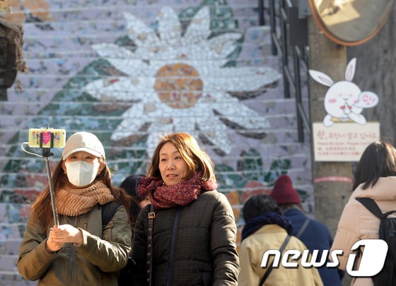 서울 종로구 이화마을에서 외국인 관광객들이 두터운 옷을 입고 거리에서 사진을 찍고 있다. /뉴스1 © News1 황기선 기자