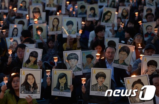 세월호 참사 2주기를 하루 앞둔 15일 오후 대전역 서광장에서 시민들이 희생당한 학생들이 그려진 그림을 들며 추모하고 있다. 2016.4.15/뉴스1 © News1 주기철 기자