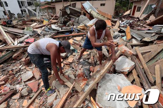 강진이 강타한 에콰도르에서 붕괴된 건물 현장에 시민들이 뛰어들어 구조를 돕고 있다.© AFP=뉴스1