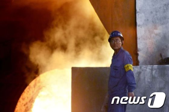 T중국 북부 허베이성에 위치한 한스틸 공장의 용광로 앞을 한 근로자가 지나가고 있다. © AFP=뉴스1