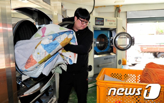 '희망리본 세탁' 서광진 대표가 세탁물을 건조기에서 꺼내고 있다. 장은진 기자© News1