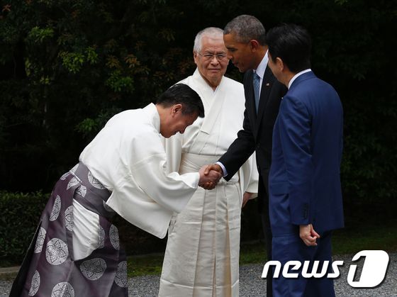 버락 오바마 미국 대통령이 G7 정상회담 첫날인 26일 (현지시간) 아베 신조 일본 총리과 함께 미에 현에 있는 이세신궁을 방문하면서 신도 승려의 환영인사를 받고 있다.© AFP=뉴스1 