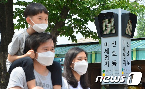 서울 광진구 어린이대공원에서 마스크를 쓴 한 가족이 미세먼지 신호등 앞을 지나가고 있다.  © News1 신웅수 기자