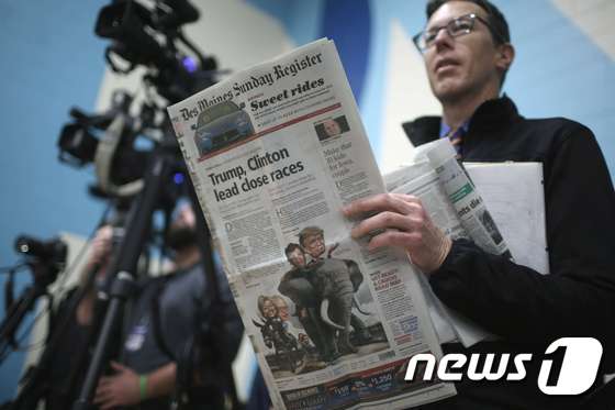  한 남성이 미국 대선 공화당 후보 도널드 트럼프의 유세장에서 신문을 읽고 있다. © AFP=뉴스1