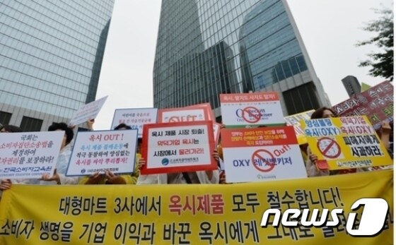 한국소비자단체협의회 회원들이 지난 24일 서울 여의도 옥시레킷벤키저 본사 앞에서 '옥시 퇴출' 피켓을 들고 있다. © News1