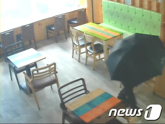 부산 중부경찰서는 29일 심야시간대 상가나 주택에 침입한 뒤 우산을 쓰고 얼굴을 가린 채 금품을 훔친 40대 남성을 구속했다고 밝혔다. 피의자가 범행당시 우산을 쓰고 지나가는 모습.(부산 중부경찰서 제공) © News1