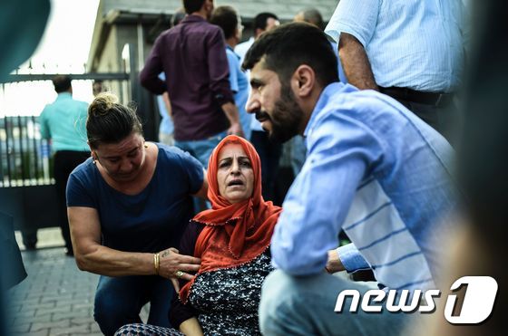 29일(현지시간) 이스탄불 공항 인근 경찰 건물 밖에서 테러로 친척을 잃고 망연자실해 있는 한 여성을 사람들이 돕고 있다. 이날 테러로 최소 36명이 사망했다. © AFP=뉴스1