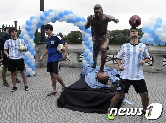 아르헨티나 팬들이 28일(한국시간) 아르헨티나 부에노스아이레스에 메시와 똑같은 크기로 만들어진 동상 앞에서 사진을 찍고 있다. © AFP=News1