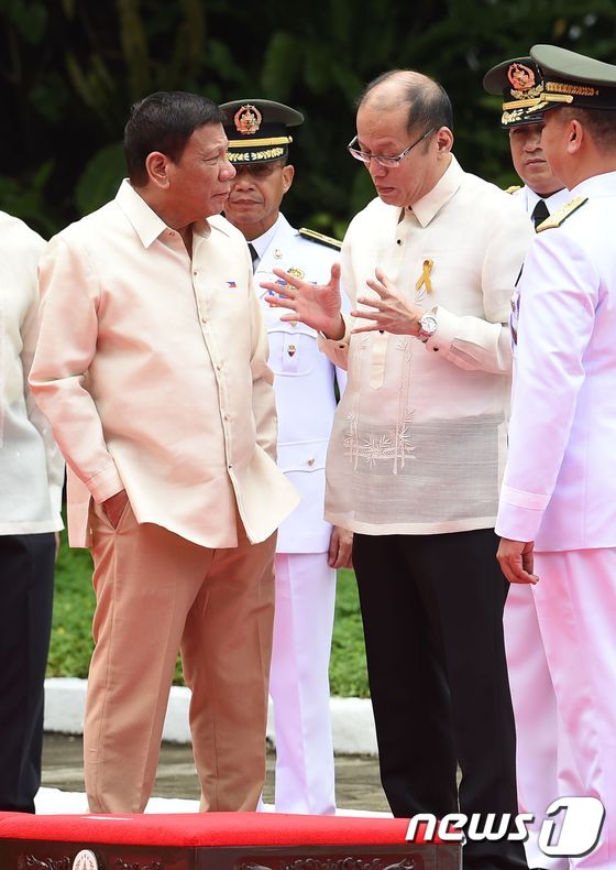 로드리고 두테르테 필리핀 대통령 당선인(가운데)이 30일(현지시간) 마닐라 소재 대통령 집무실 말라카냥 궁에서 물러나는 베니그노 아키노 대통령의 말을 경청하고 있다. 이날에는 두테르테 당선인의 취임식이 열렸다. © AFP=뉴스1