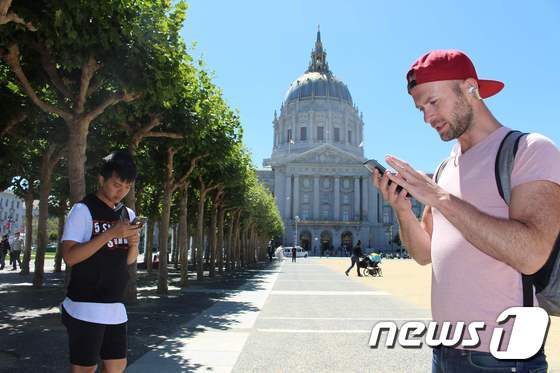 두 남성이 12일(현지시간) 샌프란시스코 시청 앞에서 포켓몬을 찾아 다니며 화제의 닌텐도 스마트폰 게임 '포켓몬 고'를 즐기고 있다.© AFP=뉴스1 © News1 김혜지 기자