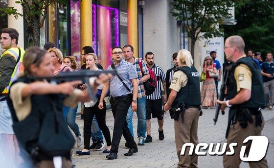 22일(현지시간) 총기난사사건이 발생한 독일 뮌헨의 올림피아쇼핑센터 인근에서 경찰이 시민들을 통제하고 있다. © AFP=News1