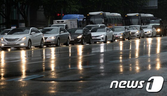 장맛비가 내리는 29일 오전 서울 종로구 종각역 네거리에서 차랑들이 전조등을 켜고 있다. /뉴스1 DB