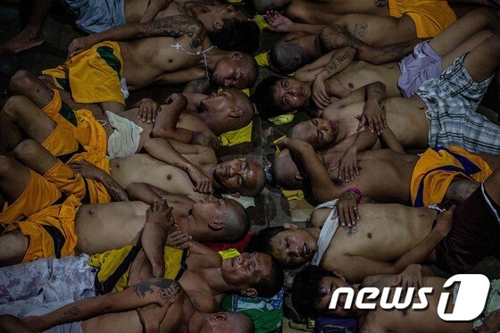 몸을 포개고 잠을 자는 수감자들 © AFP=뉴스1