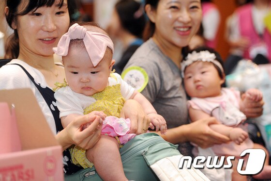 대구 수성구 호텔인터불고대구에서 열린 '건강한 모유수유아 선발대회'에 참가한 아기들이 차례를 기다리며 엄마품에 안겨 있다. 2016.7.5/뉴스1 © News1 이종현 기자