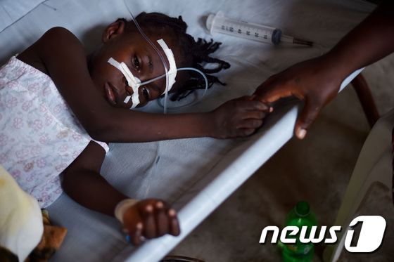콜레라에 감염된 한 소녀가 23일(현지시간) 아이티 콜레라 치료 센터의 병상에 누워 치료를 받고 있다. © AFP=뉴스1