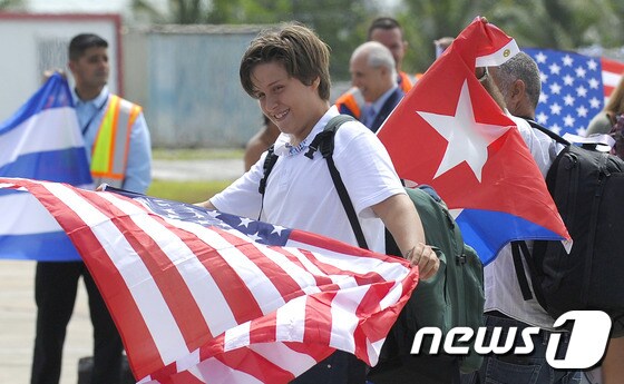  미국 승객들이 반세기 만에 처음으로 쿠바로 취항한 상업용 정기 항공편인 제트블루 소속 비행기를 타고 산타클라라 공항에 내리면서 양국 국기를 흔들고 있다. © AFP=뉴스1 