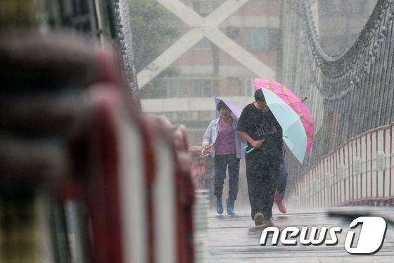  제17호 태풍 '메기'가 27일 오후 대만에 상륙할 예정인 가운데 시민들이 우산을 쓴 채 걸어가고 있다. © AFP=뉴스1