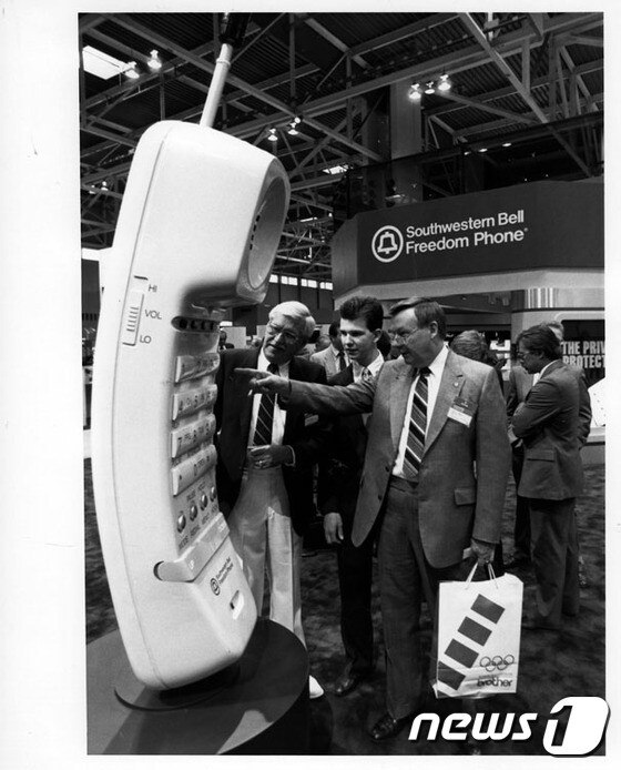 1989년 CES에서 한 참석자가 Southwestern Freedom Phone이 제작한 무선전화기의 대형 모형을 보며 놀라고 있다. (CES 제공) © News1