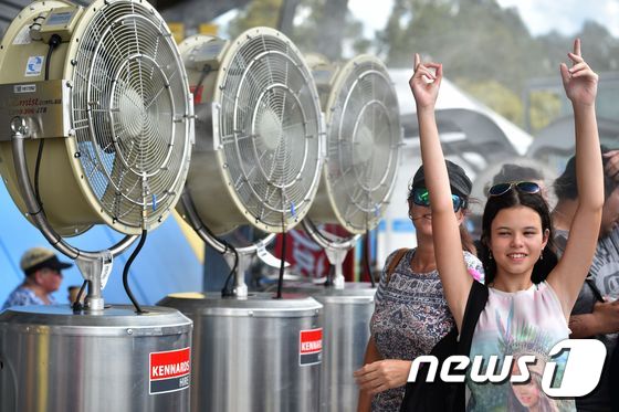 11일 호주 시드니에서 시민들이 대형 선풍기 바람을 맞으며 무더위를 식히고 있다. © AFP=뉴스1