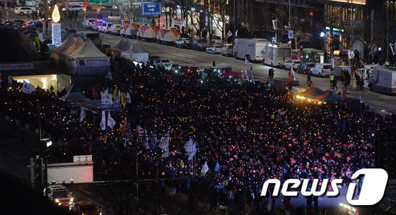 올겨울 들어 가장 추운 날씨를 보인 14일 오후 서울 광화문 광장에서 열린 제12차 범국민행동의 날 집회에서 시민들이 촛불을 들고 탄핵을 촉구하고 있다. 2017.1.14/뉴스1 © News1 구윤성 기자